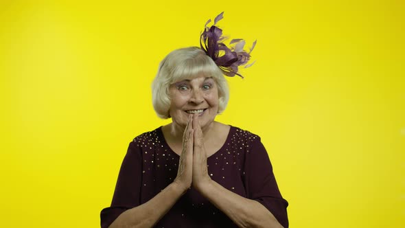 Positive Senior Old Blond Woman Appealing To Camera, Keeping Prayer Gesture and Asking Help alt
