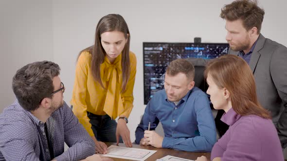 Team of Male and Female Experts Are Discussing and Examining Papers in Office Room at Work Meeting alt