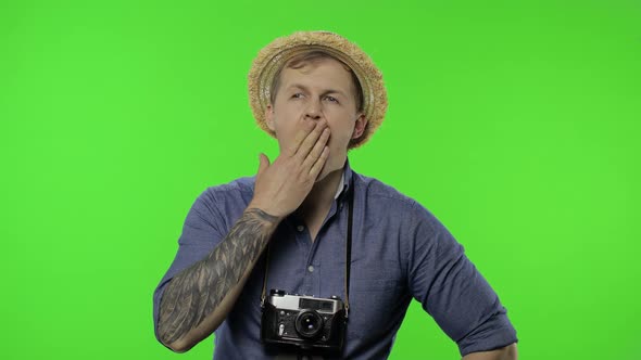 Portrait of Exhausted Man Tourist Photographer Yawns. Chroma Key alt