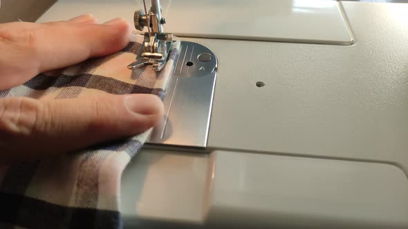 Tailor sews fabric for clothing on a sewing machine in a tailor shop alt