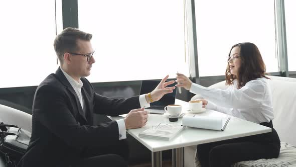 Handsome Guy in Eyeglasses Sit Talking with Colleague Have Conversation About Business Deal