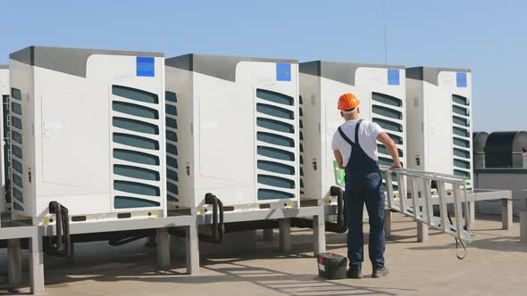 The Young Engineer is Suitable to Air Conditioners with a Ladder and a Toolbox alt