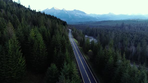 Aerial view of mountain twisted road. Epic drone footage of highway in the wild mountain scenery.
