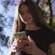 An Attractive Young Lady Using a Phone in Town. Medium Shot - VideoHive Item for Sale