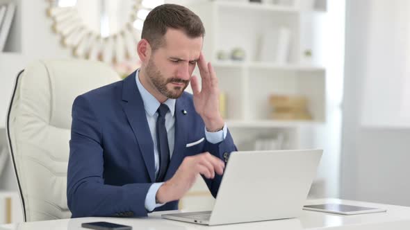 Stressed Businessman Having Headache in Office alt
