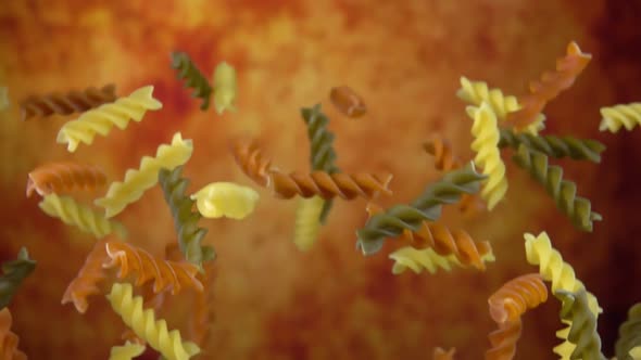 Colored Pasta Fusilli is Bouncing on a Yellow Ochre Background alt