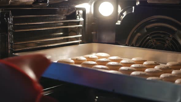 the Baker Opens the Oven Door and Takes Out Cooked Macarons