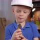 Portrait of a Small Surprised Boy in a Helmet with Tools in His Hands at Home - VideoHive Item for Sale