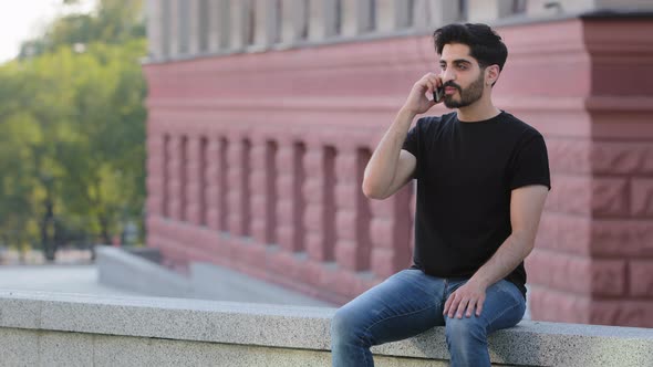 Young Bearded Indian Guy Talking on Phone alt