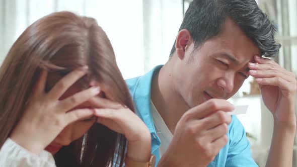Close Up Frustrated Asian Couple After Checking A Pregnancy Test alt