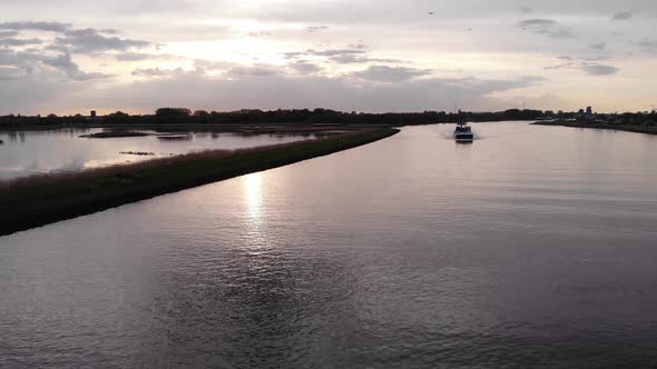 Inland Barge Travelling Across The River During Sunset In Netherlands. - aerial alt
