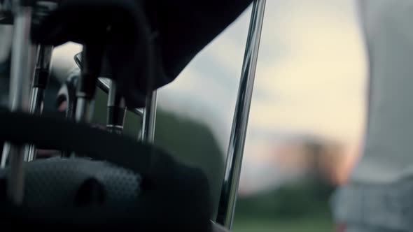 Woman Taking Golf Club at Sport Equipment Bag alt