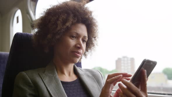 Afro American commuter on her way to work looking at smart phone