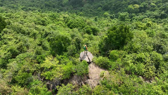Aerial footage of successful hiker enjoy the view on mountain top cliff edge alt