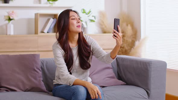 Asian girl contacts with friends through video call. Mobile distance virtual meeting. Stories of all alt