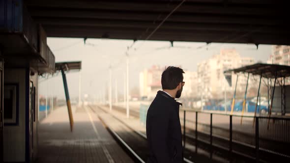 Businessman Hurries To Work And Standing On Railway Train Station Platform. Man Passenger. alt