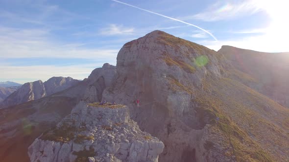 Aerial view of a man balancing while slacklining on a tightrope in the mountains. alt