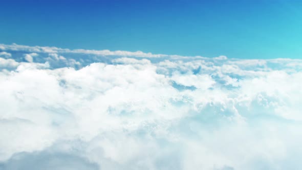 Video footage of flying above and over the clouds. Blue sky with clouds.