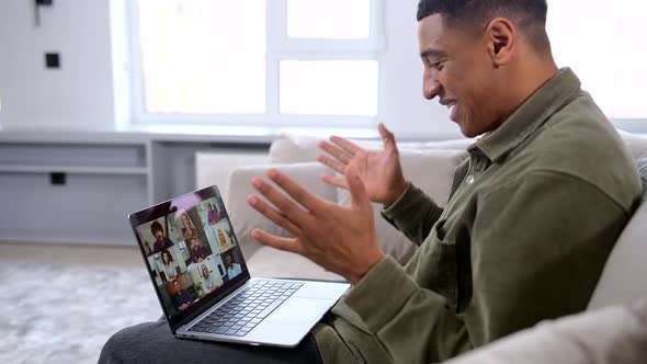 Side View of the Smiling and Cheerful Young Man Using Laptop for Video Call
