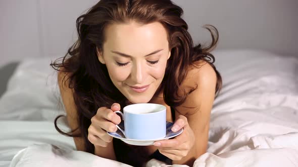 Woman drinking coffee in bed