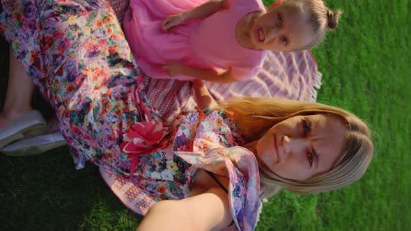 Joyful Mother and Daughter Grimacing for Mobile Phone Camera at Meadow alt