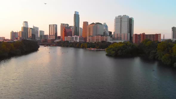 Cinematic shot of austin texas, with people enjoying the lake, and a bird flying majestically across alt