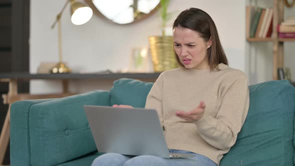 Young Woman with Laptop Reacting to Failure on Sofa alt