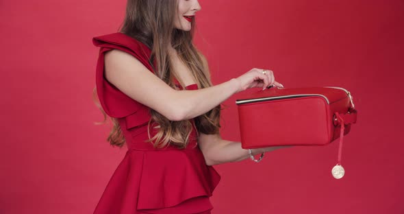 Gorgeous Brunette Woman in Red Opening Red Leather Bag and Getting Excited