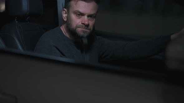 Man Sits in a Car Upset That He Was Stopped By the Police for a Traffic Violation alt