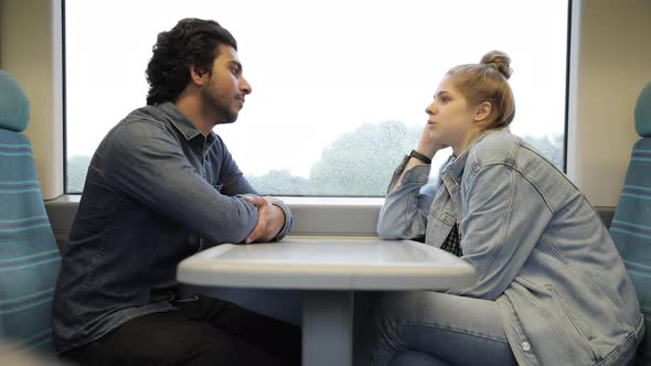 Two friends sitting inside of a train