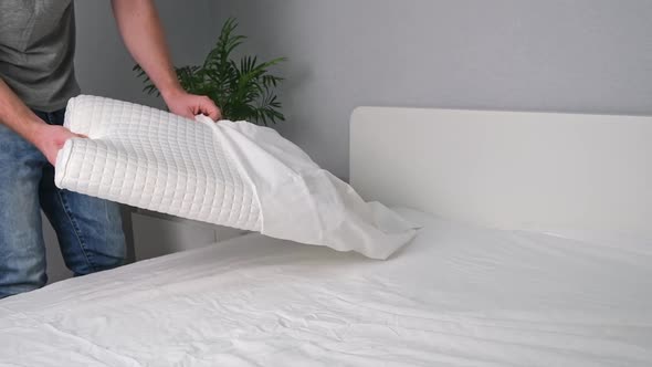 A Man Puts a Pillowcase on Orthopedic Pillow