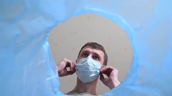 Low Angle View of a Man Throwing Disposable Medical Mask Into the Bin.