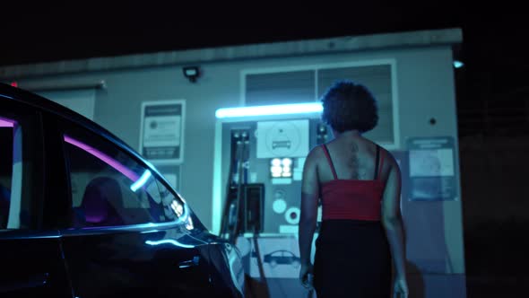 African-American Woman Charging Electric Car alt