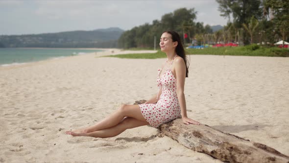 Side View of Smiling Content Lady with Closed Eyes Rest on Beach alt
