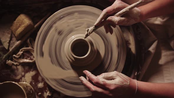 Young Woman Potter Working with a Wet Clay Working a Stick alt