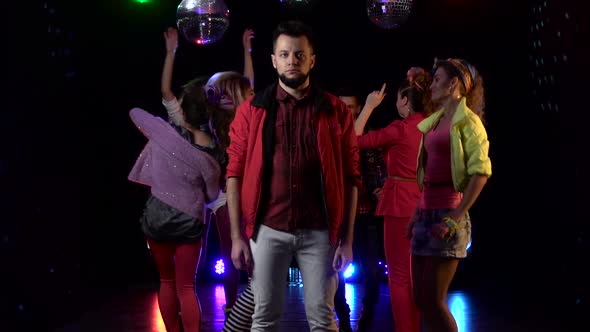 Guy Stands in Sadness Around a Crowd of Cheerful People Dancing in Their Disco . Black Background alt