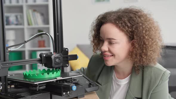 Modern Technologies Charming Woman is Watching Work of 3d Printer Smiling and Looking at Camera alt