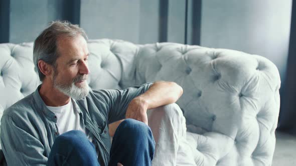 Aged Couple Sitting Near the Sofa alt