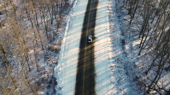 Following A Car On A Snowy Road At Sunset