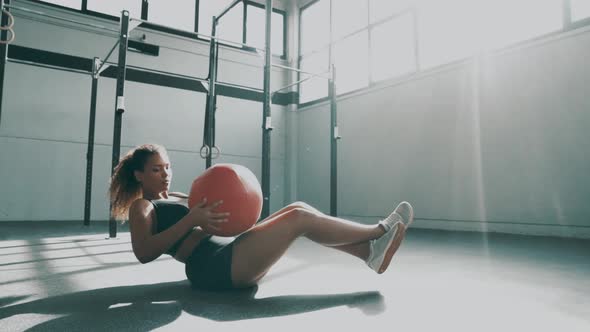 Young woman doing core training with gym ball alt