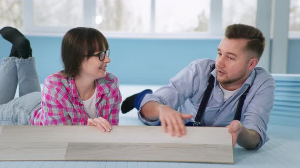 Working Team of Male and Female Specialists Lie on Floor with Expanded Polystyrene Before Laying alt
