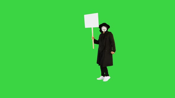 Man Wearing a Guy Fawkes Mask Holding a Blank Board on a Green Screen Chroma Key alt