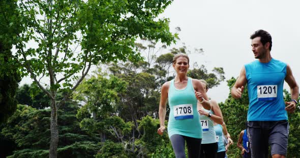 Athletic family running together in the park alt