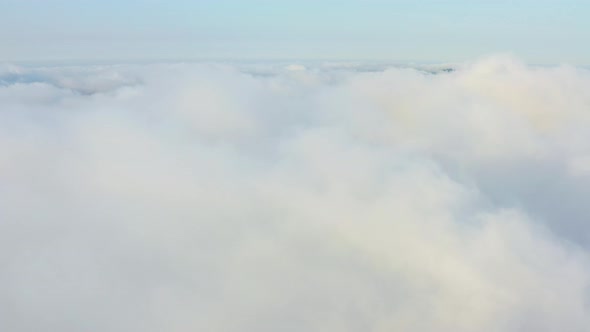 The Drone Rises From the Thick Fog Over the Beautiful Ocean of Clouds at Dawn alt