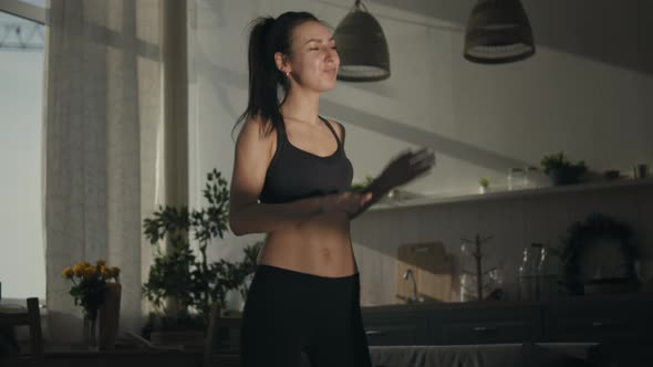 Woman Dancing To Music At Home In Sunlight alt