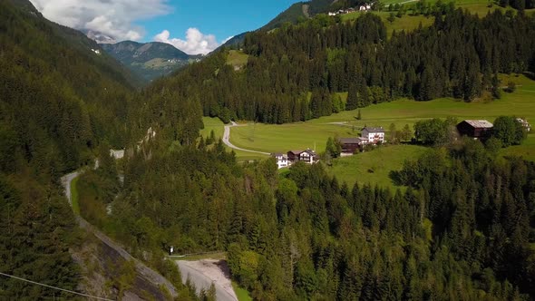 Village town at Dolomite mountains in northern Italy with the road passing through the hillside, Aer alt