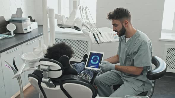 Dentist Showing Perfect Bite Image to Boy alt