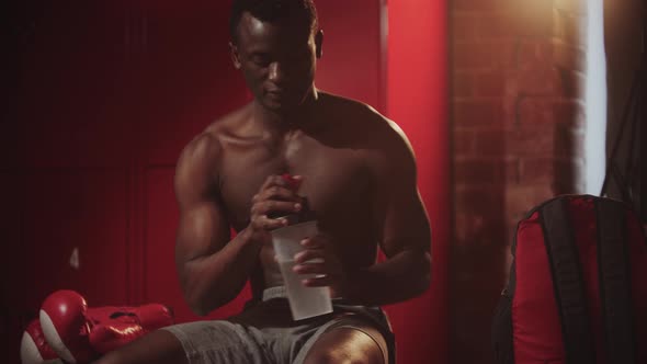 Black Young Man Boxer Getting Ready for the Training in Locker Room alt