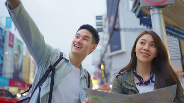 Asian active young couple travel in city for honeymoon trip at night. alt