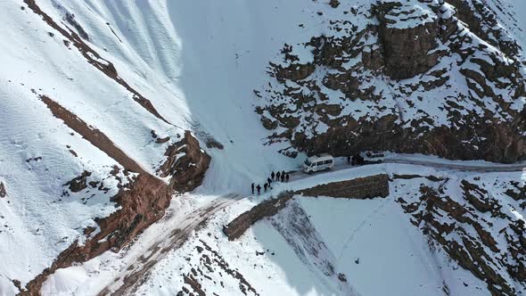 Aerial Shot of Group of Travelers Stuck in the Middle Due To Snow Block Revealing Roads Covered with alt